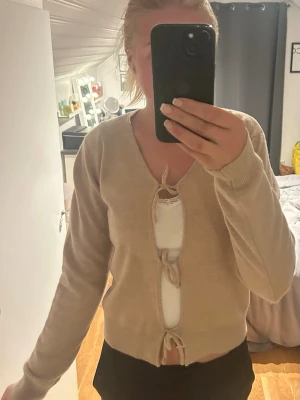 Beige kofta med knytband från Sofie Schnoor - Söt beige kofta med långa ärmar och knytband framtill.  Aldrig använd från SOFIE SCHNOOR, köpt för 500kr passar både xs och s