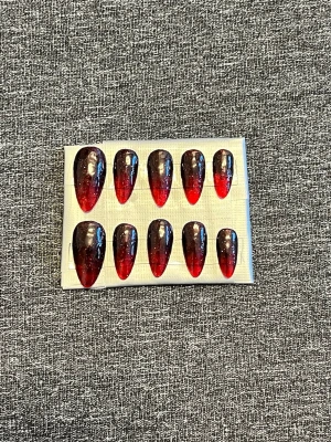 Svarta och röda press-on naglar || Storlek S - Snygga press-on naglar i mandelform med svart till röd ombre och glansig finish storlek S. Naglarna har en cool fade-effekt och lite glitter som ger extra wow-känsla. Perfekt för dig som vill ha en edgy och trendig look utan att behöva gå till salong. Det du får med dig : * Fil och manikyr pinne * nagellim klistermärken * 2 lappar av rengöring för naglar.
