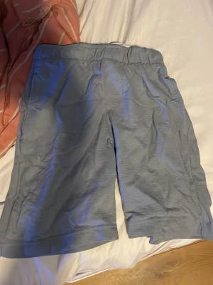 Ljusblå shorts från Free Planet - Säljer ett par ljusblå shorts från Free Planet i mjukt och bekvämt material. Shortsen har resår i midjan och raka ben, perfekta för en avslappnad stil. Passar dig som gillar enkel och clean design.