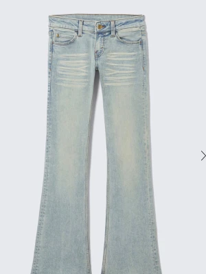Ljusblå bootcut jeans - Säljer ett par ljusblå bootcut jeans med hög midja och skinny passform upptill. Jeansen har en klassisk femficksdesign och är tillverkade i denim med lätt tvättad look. Perfekta för dig som gillar retrovibbar och vill ha ett par jeans som sticker ut.
