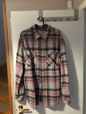 Rutig overshirt i bomull - Snygg rutig overshirt i mjuk bomull med långa ärmar och två bröstfickor. Skjortan har en klassisk krage och knäppning framtill. Färgkombinationen består av rött, blått, beige och inslag av gult. Perfekt för lager på lager och en avslappnad stil. Storlek M! 