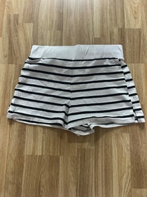 Randiga shorts  - Randiga shorts från Kappahl i storlek L. Men de är väldigt stretchiga och skulle säga att de kan passa en M. Det är ingenting fel på shortsen, jag säljer dem pga att de inte är min stil längre. Vill du ha fler bilder på dem? Kontakta mig så fixar jag!