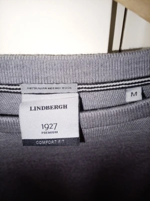 Grå stickad tröja från Lindbergh - Snygg grå stickad tröja från Lindbergh i Australian merinoull. Tröjan har rund halsringning, långa ärmar och en enkel, stilren design. Comfort fit för extra bekvämlighet. Perfekt till höstens och vinterns outfits. 1399 i butik