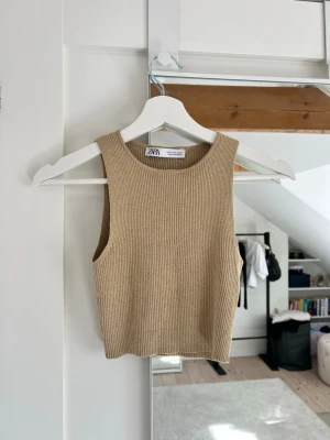 Guld topp - En guld färgad ribbad kort topp från Zara i storlek S. Den är croppad, har stretchigt material och är kroppsnära. Den är använd typ en gång :)