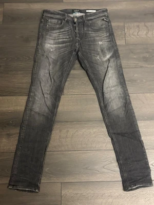 Mörkgrå jenas med slitningar - Säljer ett par mörkgrå replay jeans med slitningar och tvättade detaljer.                         W30 L34