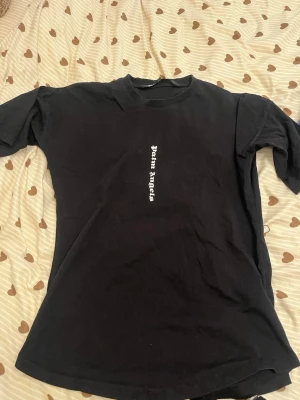 Svart t-shirt med tryck - Säljer en stilren svart T-shirt i storlek XL med snyggt vitt tryck både fram och bak. Texten löper vertikalt längs mitten, vilket ger en modern och unik look. Tröjan har en skön, lite rymligare passform som passar perfekt till en streetstyle-outfit. • Färg: Svart med vitt tryck. • Storlek: XL. • Skick: Bra begagnat skick. Notera: Den är lite nopprig runt halslinningen (se närbild), men inget som påverkar användningen. • Detaljer: Tryck på både fram- och baksida  ✨ Kika gärna på mina andra varor 