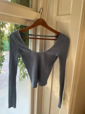 Ribbad blå croppad topp - En jätte fin lång ärmad topp men en sån fin blå färg, urringning fram och en en öppen rygg där bak med ett bland långt upp som man har styra om om de skulle viljas, skriv gärna om du vill ha flera bilder🥰använd två eller tre gånger så den är som ny 