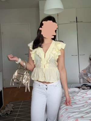 Gul volangblus - Säljer en jättefin topp med volanger från Nelly. Färg: smörgul. Storlek 36 (passar storlek XS–S). Använd en gång; bara lite skrynklig efter att ha legat undanlagd. 🤍