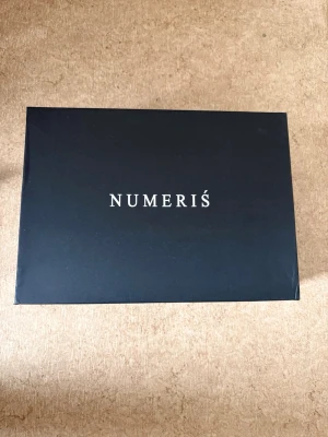 Numeris sneakers i grått mönster - Snygga sneakers från Numeris i en unik grå och vit camo-liknande design. Skorna har en chunky vit sula med räfflat mönster och ovandel i textilmaterial. Perfekta för dig som vill sticka ut med din stil.