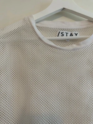 Vit mesh topp från Carlings  - Säljer en vit mesh topp från Carlings med rund halsringning och korta ärmar. Toppen är helt genomskinlig med ett sportigt nätmönster, perfekt att styla över ett linne eller bikini. Superlätt och luftig för varma dagar.