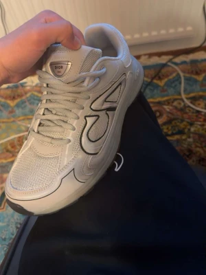Gråa B30 - Säljer ett par gråa b30 sneakers med coola detaljer i svart och grått. Skorna har en blandning av mesh och läder, samt CD-logga på hälen. Snygg, chunky sula och klassisk snörning. Perfekta för dig som gillar exklusiva och trendiga sneakers. Pris kan diskuteras vid snabb affär och är även öppen för bud. Tvättas även innan köpet.