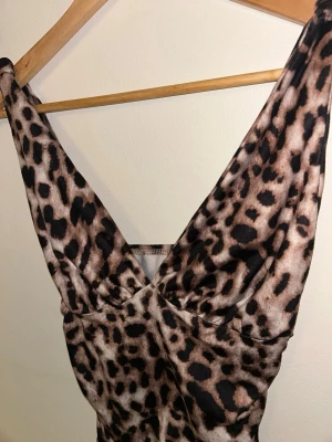 Leopardmönstrad croppad topp - Snygg croppad topp med leopardmönster och djup v-ringning. Toppen är ärmlös och har en figurnära passform som framhäver siluetten. Perfekt för dig som vill sticka ut med ett trendigt djurmönster.