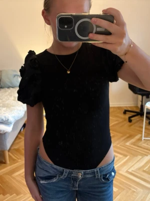 Svart body - En svart body men puffiga ärmar som sitter tajt i midjan. Den är använd fåtal gånger så är i väldigt bra skick. 