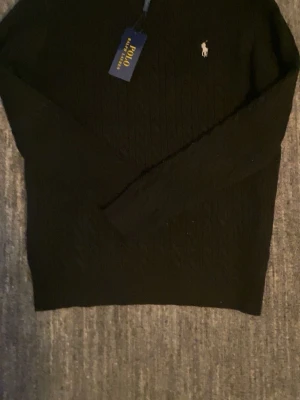Svart stickad Polo Ralph Lauren tröja  - Svart stickad tröja från Polo Ralph Lauren i sjukt bra kvalité eftersom den även är helt ny. Passar dig som är ute efter en snygg stil. Priset kan diskuteras vid snabb affär.