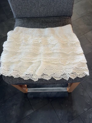 Spets shorts Chelsea  - Säljer ett par vita virkade shorts med fina volangdetaljer. Shortsen har en låg midja! De är aldrig använda!  