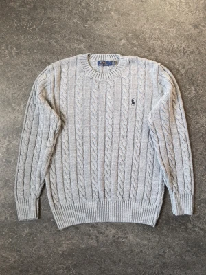 Ljusgrå kabelstickad tröja Polo Ralph Lauren - 👕 Plagg: Quarter zip 📏 Storlek: S 🏷️ Märke/modell: Polo Ralph Lauren cable-knitted ✨ Skick: Väldigt bra skick, 7/10. Bara några stickproblem  Vid frågor eller funderingar är det bara att skriva! Tveka inte på att lägga ett bud för enklare business!🤝