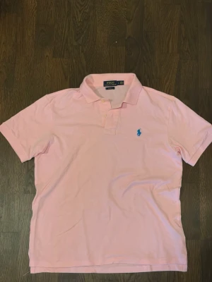 Rosa Ralph Lauren piké - En rosa Ralph lauren piké.  Skick 9/10. Den är nästan i nyskick. Priset är ej hugget i sten! 