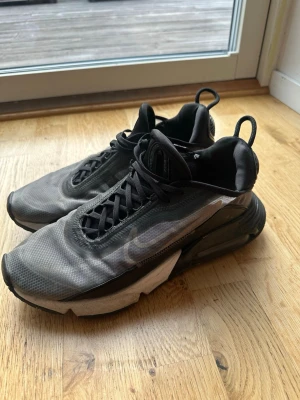 Nike Air Max 2090 svarta sneakers - Nike Air Max 2090 sneakers i svart och grått med transparent mesh-överdel, svarta detaljer och synlig Air Max-sula. Bra skick 