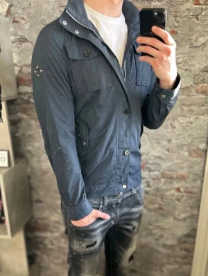 J.Lindeberg Field Jacket - Mycket fint skick nga defekter, priset e verkligen it hugget i sten!!. Storlek S, passar dig som är mellan 170–185 cm ungefär. Nypris ca 4000 kr. Modellen är 185 cm och väger 79 kg. Självklart äkta. Skriv för mer information! 🤝Obs it mina bilder men köpt från Bonde Clothing Co.