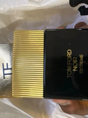 Tom Ford Noir Extreme EdP 50ml - Tom Ford Noir Extreme Eau de Parfum i en lyxig svart och guld flaska. Flaskan har en elegant, fyrkantig form med räfflat guldfärgat lock och matchande guldig kartong. Innehåller 50 ml doft som utstrålar exklusivitet och stil.