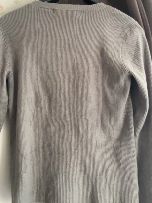 Grå ribbstickad tröja Polo Jeans - Säljer en grå ribbstickad tröja från Ralph Lauren Polo Jeans. Tröjan har lång ärm, rund halsringning och är tillverkad i bomull. Enkel och stilren design som passar perfekt till många olika outfits.