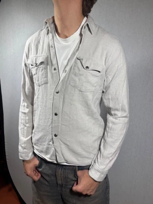 Ciszere overshirt XS - Hej och välkommen till byTorén. Detta är en overshirt från Ciszere i storlek S men sitter som XS. Modell på bild är ca 182, 67kg. Plagget är i bra skick utan några defekter, men är lite nopprigt. Tveka inte på att höra av dig, även om det skulle vara minsta lilla;)