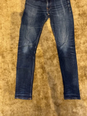 Nudie jeans - Helt okej skick på dessa jeans 👖 Har ett hål i skrevet och i fickan 👌  Perfekt för dig som vill ha ett par snygga nudies med snygga fades!Storlek:W29 L32.                            Modell: lean Dean 