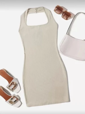 Beige ribbad kort klänning - Trendig beige ribbad kortklänning med fyrkantig halsringning och ärmlös design. Perfekt för dig som gillar en enkel men snygg stil. Klänningen har en kroppsnära passform och är tillverkad i ett mjukt, stretchigt material.