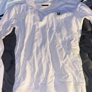 Råsa  tröja från Lyle & Scott Junior - Säljer en stilren råsa tröja från Lyle & Scott Junior. Den har en liten gul logga på bröstet och är i bra skick. Perfekt för både vardag och skola. Tröjan är långärmad och gjord i ett mjukt material som känns skönt mot huden.