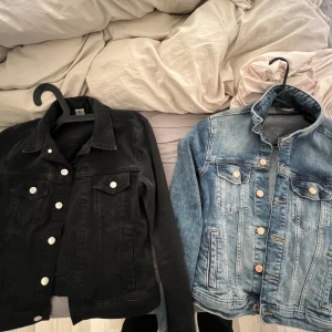 Svart och blå jeansjacka - Två snygga jeansjackor till salu! Den ena är klassiskt svart, perfekt för en cool look. Den andra är blå med en vintage tvätt, supertrendig för våren. Båda har långa ärmar och bröstfickor. Perfekta för att styla upp vilken outfit som helst!99st