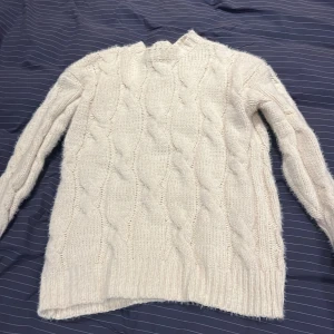 Vit kabelstickad tröja  - Mysig vit stickad tröja från Sinsay i storlek XXS men sitter mer som S. Superfin till både jeans och kjol! Köpt här på plick men har inte kommit till användning av mig. Mysig och sticks inte. Kom gärna med prisförslag!