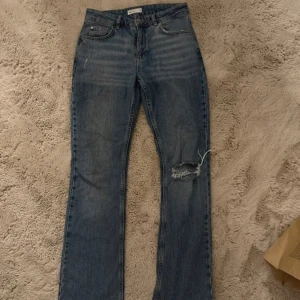 Blå jeans med slitningar - Säljer ett par snygga blå jeans i bra skick med hål på ena knät, dock förstora för mig.. pris går att diskutera☺️