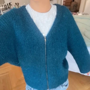 Blå stickad kofta med dragkedja - Mysig blå stickad kofta från COS med dragkedja framtill. 