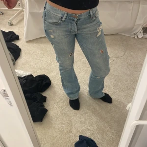 Ljusa jeans med slitningar - Säljer ett par ljusa jeans i bra skick med coola slitningar. De har en normal passform och är perfekta för en avslappnad stil. Jeansen är i klassisk denim och har en bekväm midwaist. Perfekta för både vardag och fest! Jag ör 172 lch på mig är dem lite långa❤️pris kan diskuteras