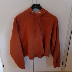 Orange Hoodie Från Lager 157 - Orange kortare hoodie från lager 157 NEU i storlek M/L. Inga tydliga tecken på användning men köpt på loppis för nåt år sedan.  Katt finns i hemmet