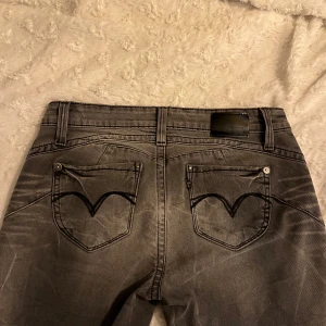 Lågmidjade gråa Levi’s bootcut Jeans - Säljer ett par skitsnygga gråa Levi's Revel jeans som jag sytt om till bootcut, då de är lite för små för mig tyvärr. De har en snygg dragkedjedetalj på fickan och är i mycket bra skick.   🩷midjemått - 39cm innerbenslängd - 77cm