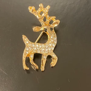 Renbroscher i guld och silver - Säljer tre stiliga renbroscher i olika utföranden. En i guld med glittrande stenar, en i silver med detaljerade horn och en i matt guld. Perfekta för att piffa upp din outfit under julen eller vintern. Passar både till fest och vardag!      55kr/st , samma frakt 