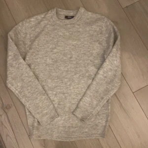 Grå stickad tröja  - Säljer en stilren och bekväm grå stickad tröja. Perfekt för kyliga dagar med sin mjuka och varma känsla. Tröjan har långa ärmar och ribbade muddar vid ärmslut och nederkant. Passar både till vardags och lite finare tillfällen. Den är i nyskick använd 1 gång.  Tröjan är i storlek Xs men passar med S. Prisförslag är möjliga!