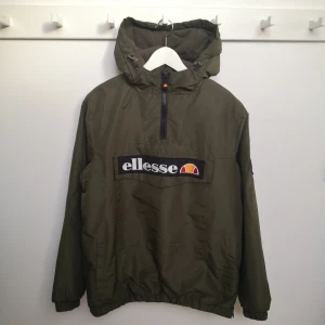 Grön vinterjacka från Ellesse - Grön vinterjacka från Ellesse herr. Storlek M. Mycket fint skick. Stor ficka med lock framtill, och sidfickor. Köparen står för fraktkostnaden. 
