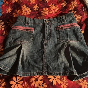 Jeanskjol med rosa detaljer från yes or no - Säljer en cool jeanskjol från Yes or no i storlek L. Den har snygga rosa dragkedjedetaljer på fickorna och en klassisk jeanslook. Perfekt för en avslappnad stil eller en utekväll. Kjolen är i bra skick och redo för nya äventyr! 💖