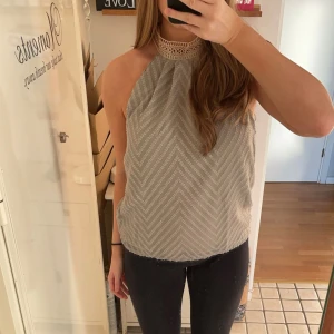 Grå ärmlös topp med spetsdetalj - Säljer en snygg grön ärmlös topp med ett diskret sicksackmönster. Aldrig använd så i väldigt bra skick. Perfekt för både vardag och fest ❤️