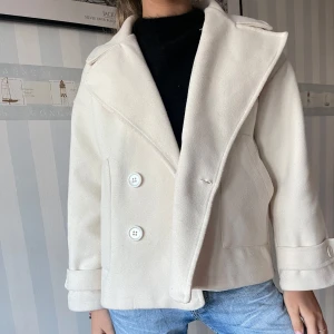 Beige Kappa  - Säljer denna kappa i superfin beige färg, perfekt till vintern och hösten. Den är från design by si och superfin att ha till dina outfits då den passar allt!