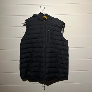 Svart dunväst med dragkedja ifrån Pjs.  - Säljer en dunväst med luva från Parajumpers. Lätt använd, skick 8/10.