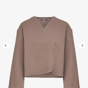 Säljer en stilren beige kavaj/ jacka från Gina tricot Den har en omlott-design med subtila sömmar som ger en elegant touch. Perfekt för både vardag och fest. Passar bra till höst och vår.