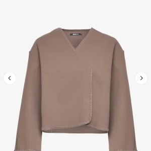 Beige kappa/kavaj - Säljer en stilren beige kavaj/ jacka från Gina tricot Den har en omlott-design med subtila sömmar som ger en elegant touch. Perfekt för både vardag och fest. Passar bra till höst och vår.