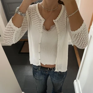 Vit stickad kofta  - Trekvartsärmad vit stickad kofta med mönster från Mademoiselle. Kan inte hitta storlek men skulle säga S/M. Fint skick. Använd gärna köp nu!