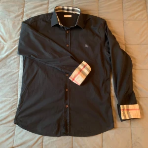 Burberry skjorta - Burberry skjorta i bra skick bortsett från en defekt man kan se på sista bilden! Tveka inte på att höra av er vid funderingar 😊storlek: M skick 7/10