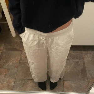 Vita linnebyxor  - Säljer ett par vita utsvända linnebyxormed hög/ mid midja, går att vika ner till low.  Använd  men är i bra skick. Storlekslappen är bortklippt men är ungefär i S