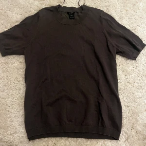 Grå kortärmad tröja från Lindex  - Säljer en stilren grå tröja från Lindex. Den är kortärmad och har en normal passform, perfekt för både vardag och lite finare tillfällen. Materialet känns mjukt och bekvämt. Den är aldrig använd, endast testad och köpt för 400 kr på Lindex