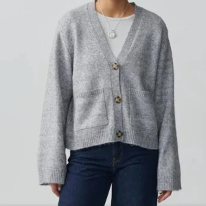 Grå kofta med knappar - Mysig grå kofta i mjukt material med stora knappar framtill. Den har en avslappnad passform och två praktiska fickor. Perfekt för kyliga dagar och att mysa i hemma. Passar till både jeans och kjol! Skriv för egna bilder❤️❤️ nypris 459kr passar lika bra som S också